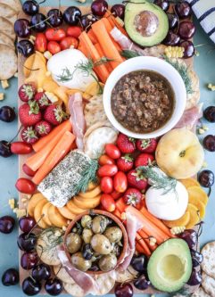 An easy summer crudite platter with sliced veggies, seasonal fruit, creamy cheeses and fresh herbs. Basically summer on a plate!