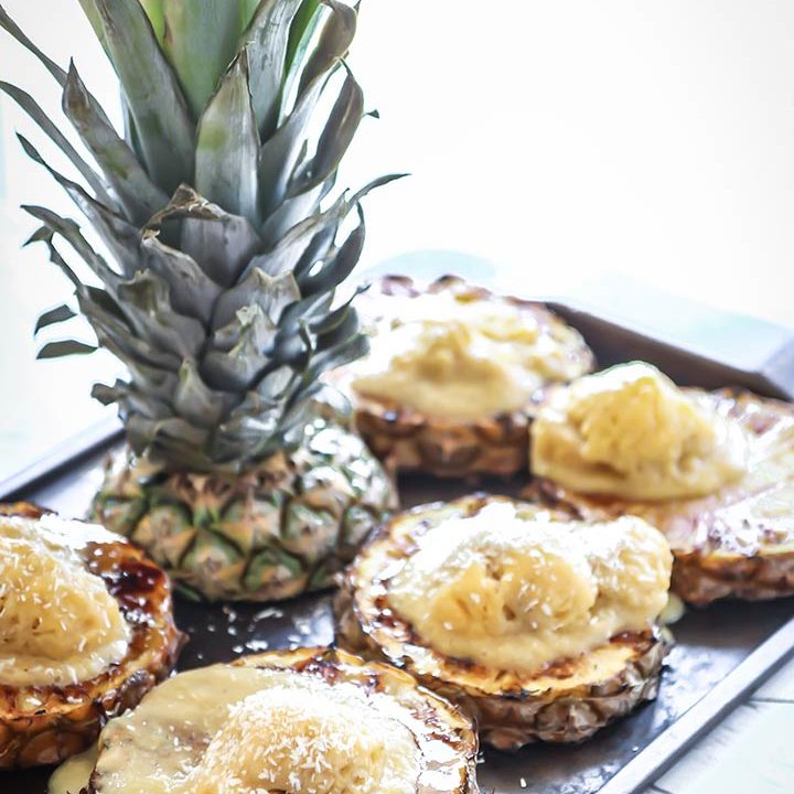烤菠萝用芒果香蕉漂亮的奶油饰有新鲜的椰子和波旁酱毛毛雨，新鲜和鲜美的热带夏季享受！