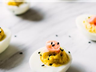一只芥末姜弃有的鸡蛋用在顶部的腌姜在顶部在大理石板块装饰用黑芝麻籽。