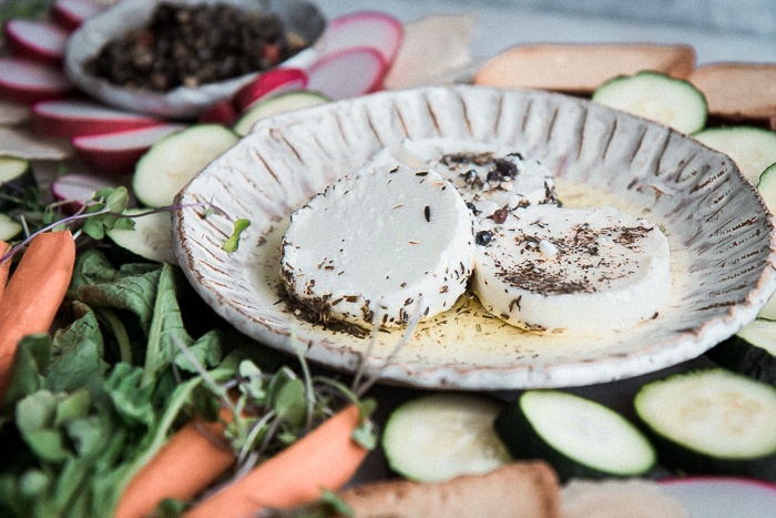 有希腊白乳酪和被分类的未加工的蔬菜的一块白色板材在盛肉盘。