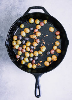 一个黑色的碗，里面有早餐土豆、熟蔬菜和蒜泥蛋黄酱。