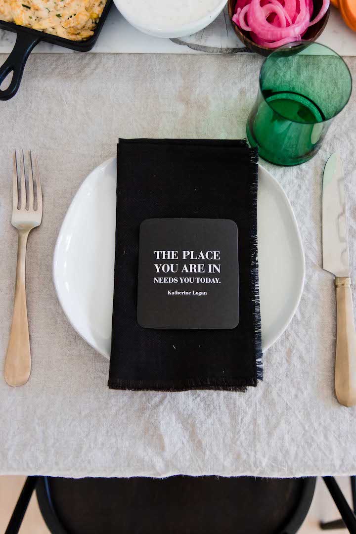 一块白色板材的照片有一个黑餐巾的与一个绿色玻璃。