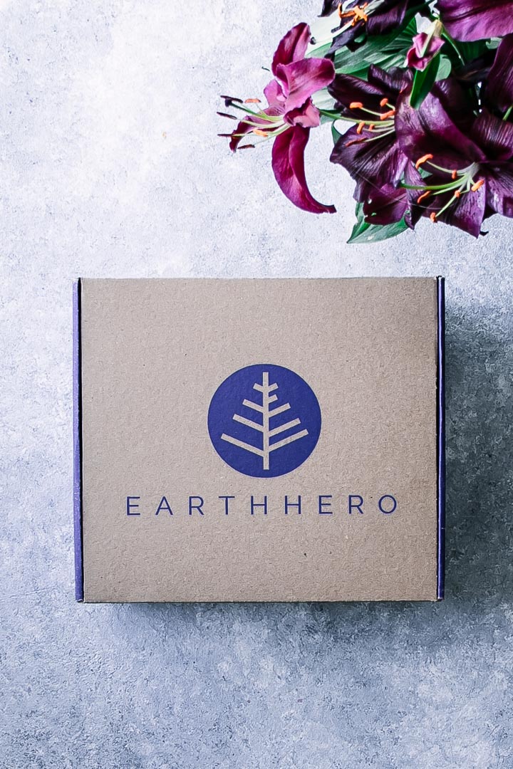 《地球英雄》的纸质订阅盒放在蓝色的桌子上，桌上放着鲜花