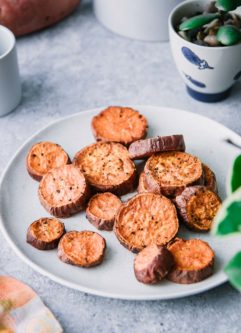 蓝色的桌子上，白色的盘子上放着香脆的素食甘薯角