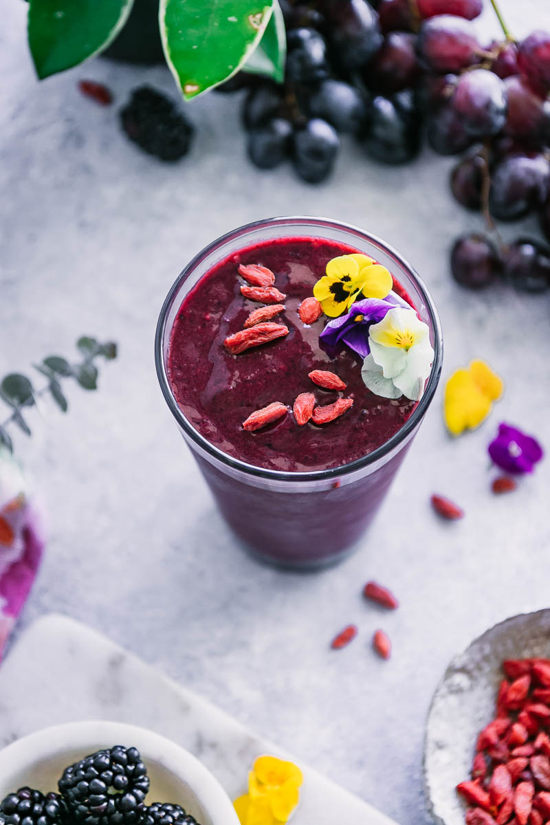 巴西莓奶昔装在杯子里，里面有花、浆果和葡萄