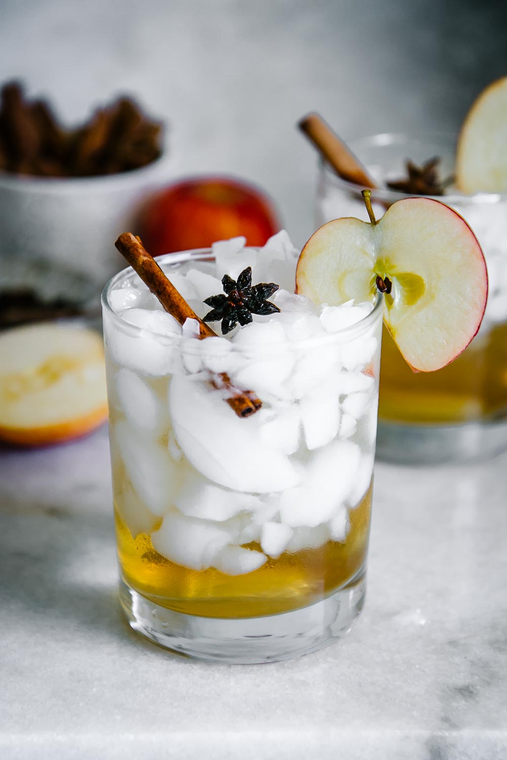 一块玻璃与冰和苹果汁醋和闪光水与苹果切片在白色桌上装饰