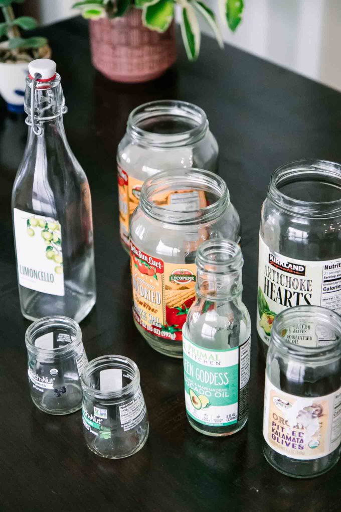 木桌上挂着标签的各种各样的空玻璃食品罐