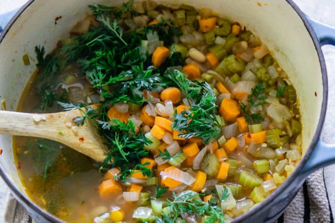 用木勺把胡萝卜拌进汤里