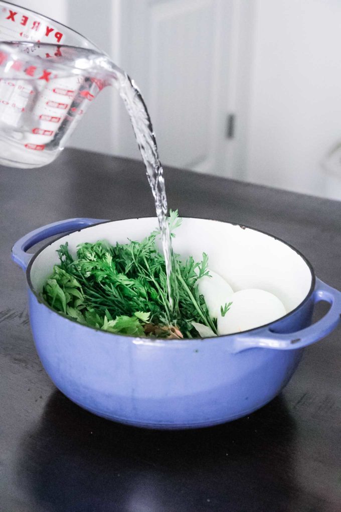 浇灌浇进装满蔬菜和草药的汤锅
