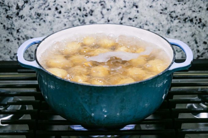 奶精土豆在黑色炉灶在蓝色煲沸gydF4y2Ba