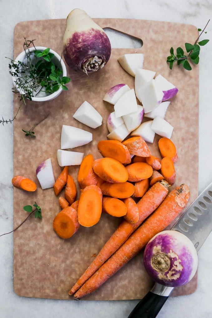 切片胡萝卜，萝卜，新鲜的草药和刀具上的一把刀