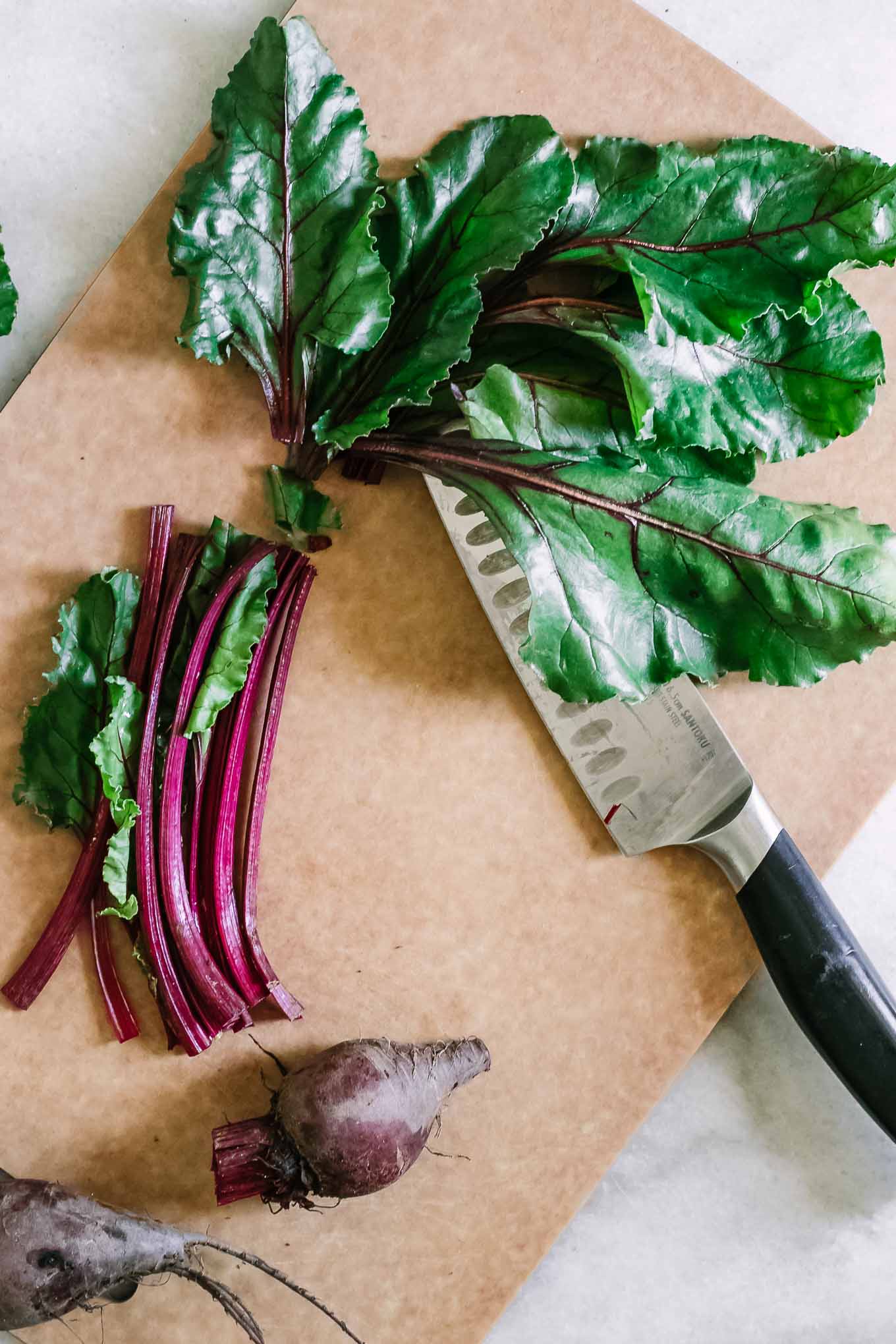 用黑刀在切菜板上切甜菜蔬菜