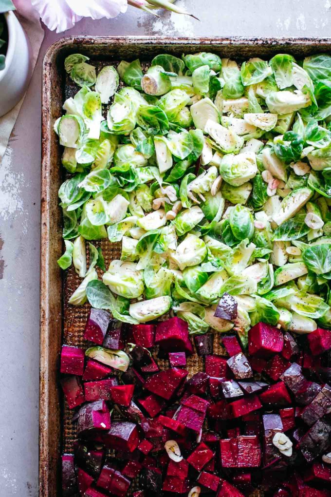 经验丰富的未煮过的切碎的红色甜菜和抱子豆芽在纸板上