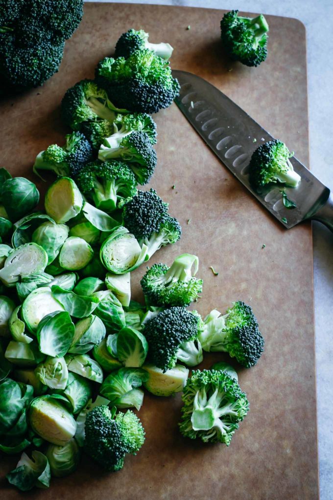 用刀在切菜板上切球芽甘蓝和花椰菜