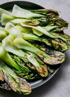 白色桌子上放着蓝色盘子里的烤白菜片