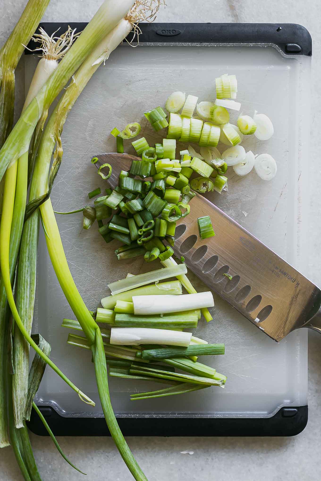 切成薄片和切成切菜板上的绿色洋葱的长矛GydF4y2Ba