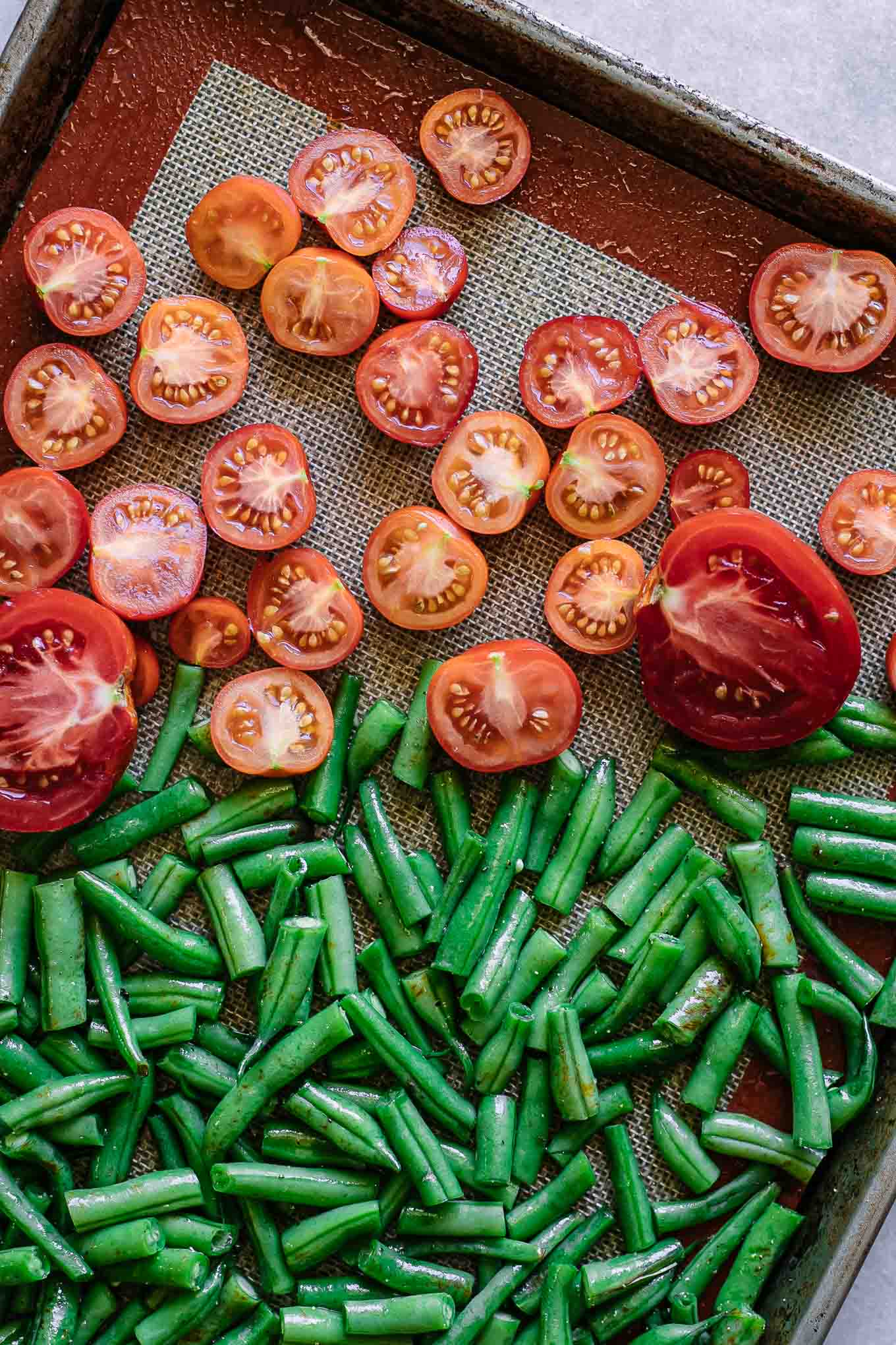 切成薄片的绿豆和西红柿在烤盘上GydF4y2Ba