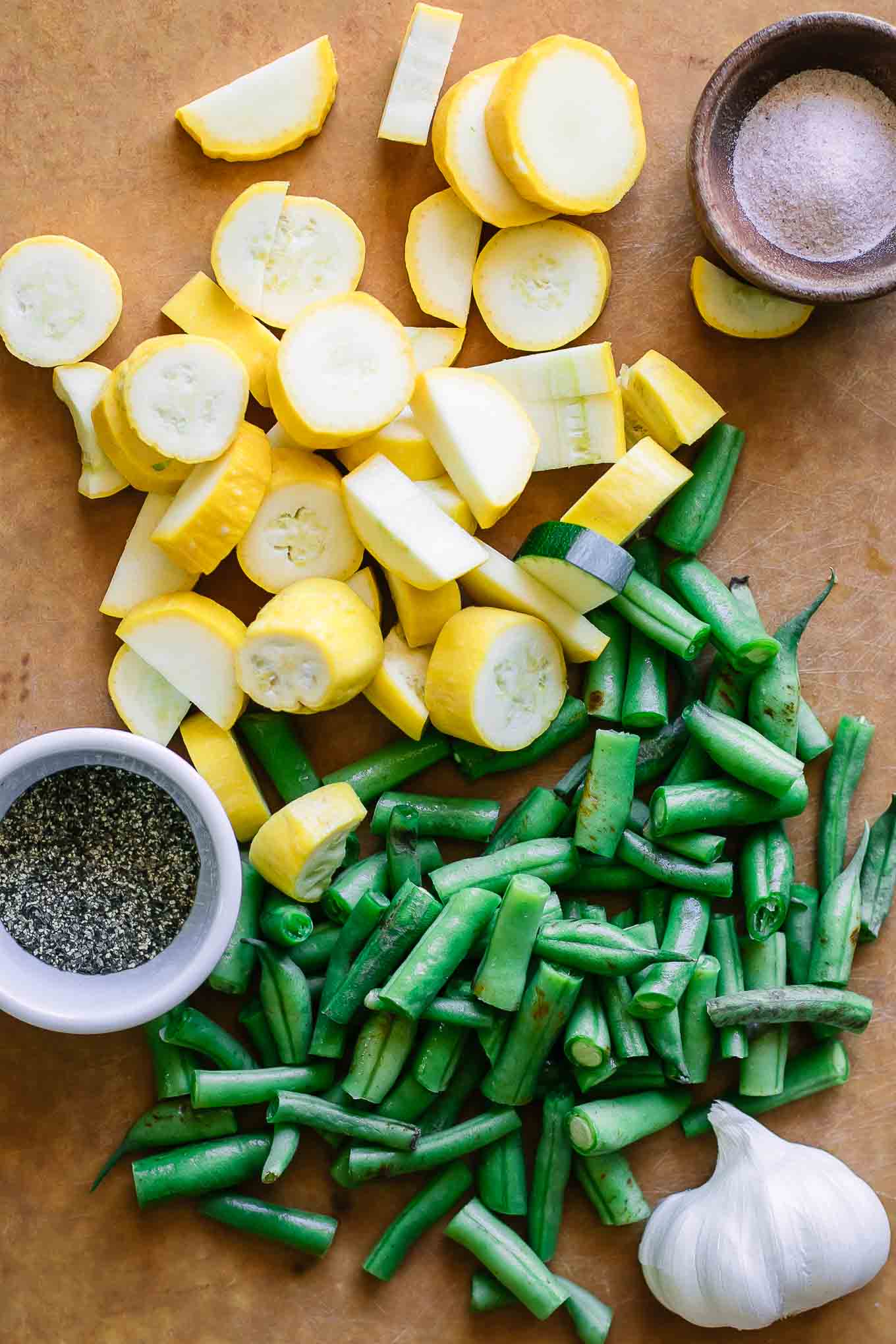 切成薄片的黄色夏季南瓜和切菜板上的绿豆切成薄片GydF4y2Ba