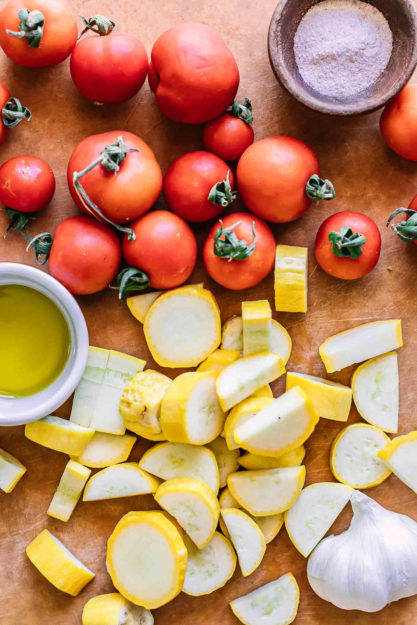 樱桃番茄和切成薄片的黄色夏季南瓜在木材切菜板上GydF4y2Ba