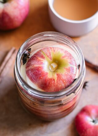 把苹果切片放入放入腌制罐中的卤水中，放在木桌上，与整只苹果和几碗醋放在一起