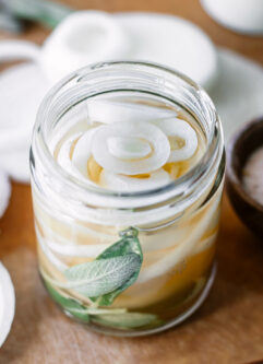 玻璃罐中腌制的白洋葱和香草