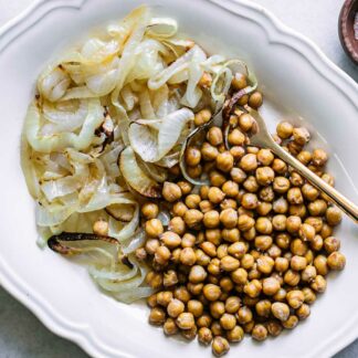 一个白色板烤鹰嘴豆和洋葱一个白色的桌子上gydF4y2Ba